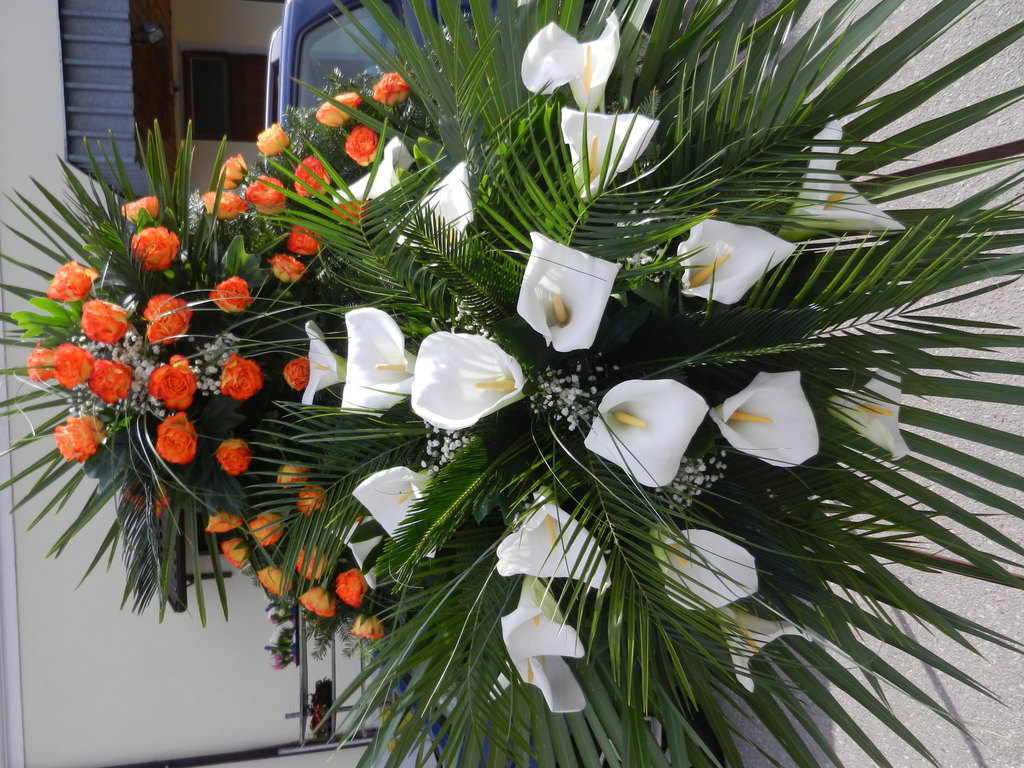 Wiązanka pogrzebowa z pomarańczowymi różami oraz białymi kaliami